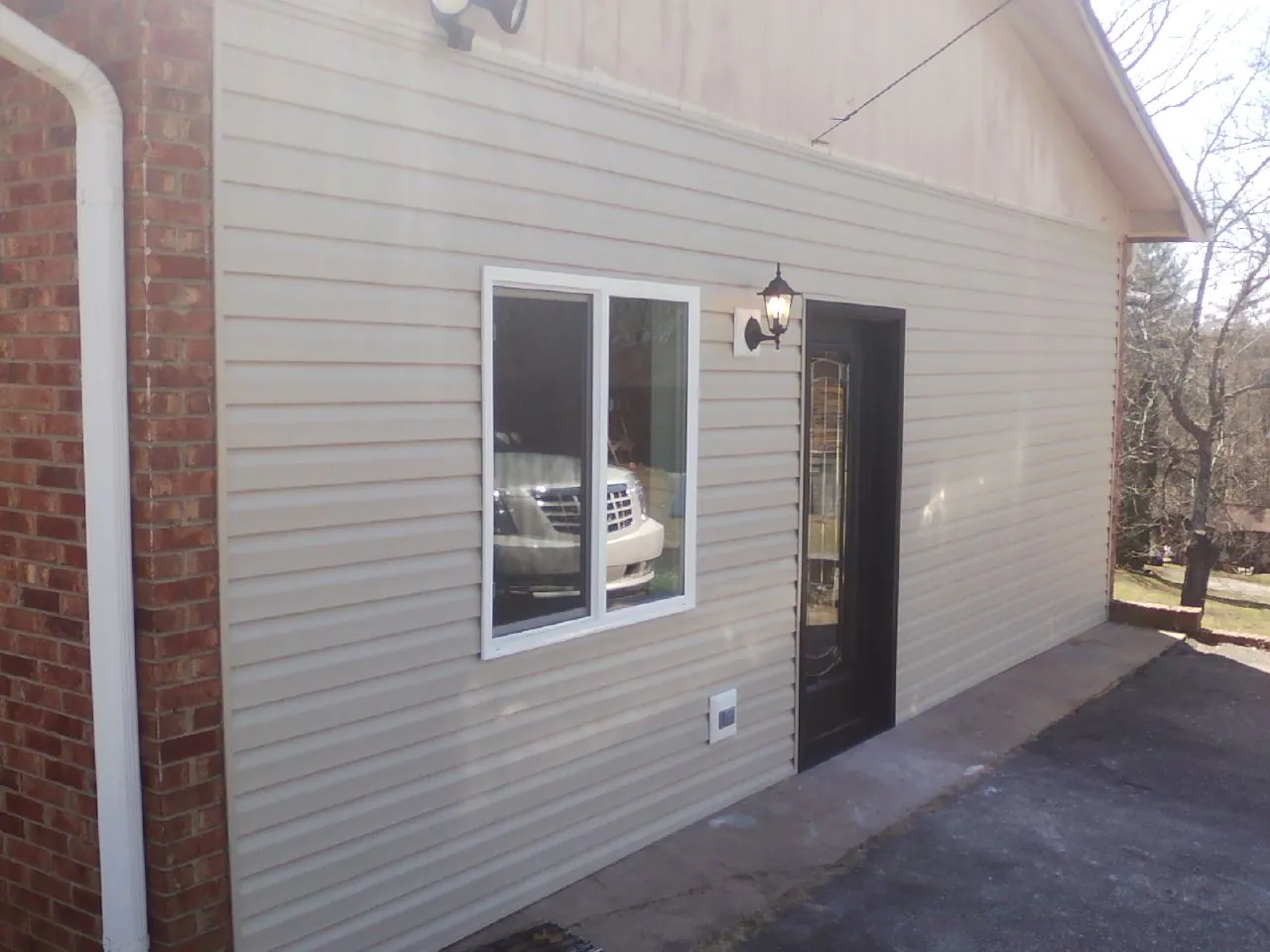 New vinyl siding and entry door on a room addition in Mc Kean