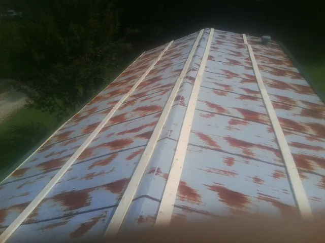 Rusted metal roof panels with new wood purlins before replacement — Storm Damage Roof Repair in Mc Kean by Roofing Brothers