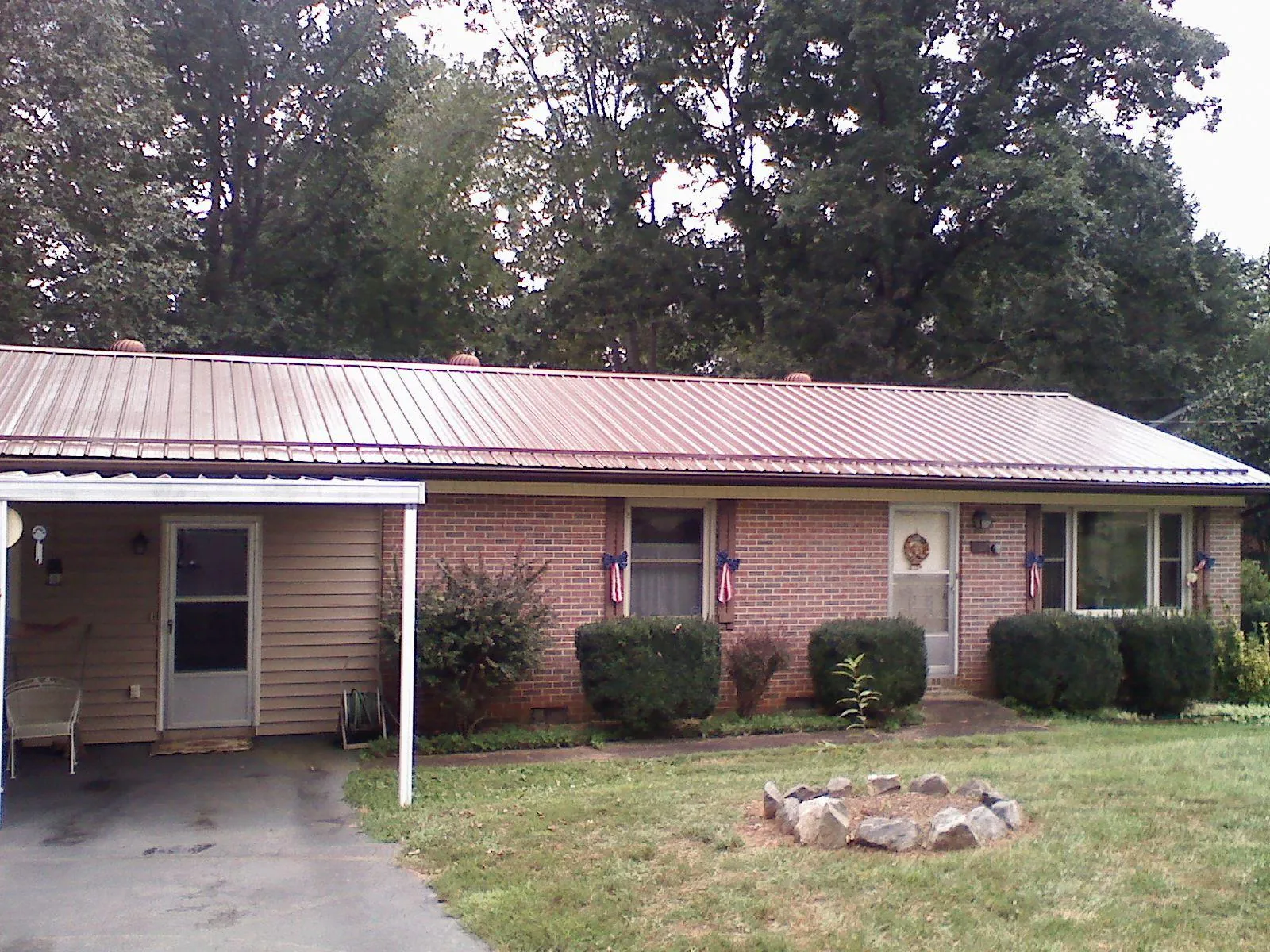 Bronze metal roof and carport on a brick ranch home — Roof Repair work by our crew in Mc Kean